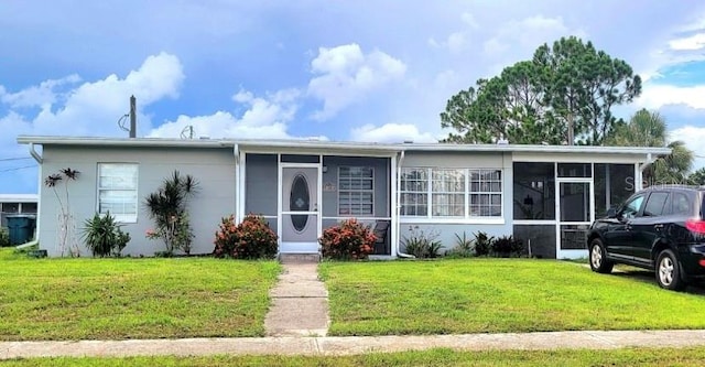 ranch-style home with a sunroom and a front lawn