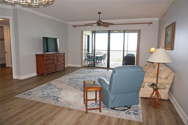 living room featuring dark hardwood / wood-style flooring, ceiling fan, and ornamental molding