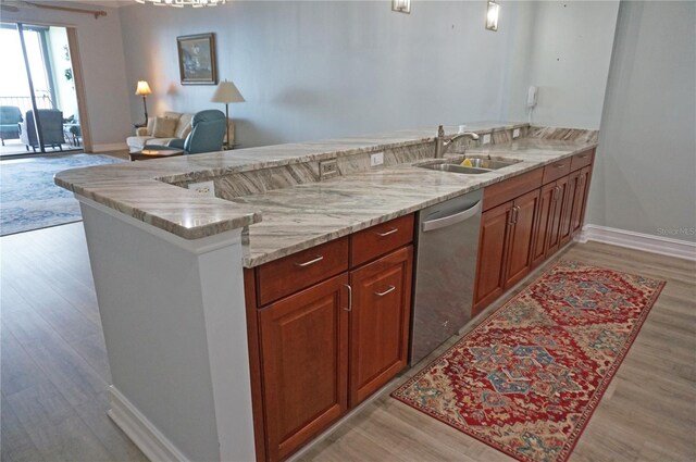 kitchen featuring dishwasher, sink, light hardwood / wood-style flooring, light stone counters, and kitchen peninsula