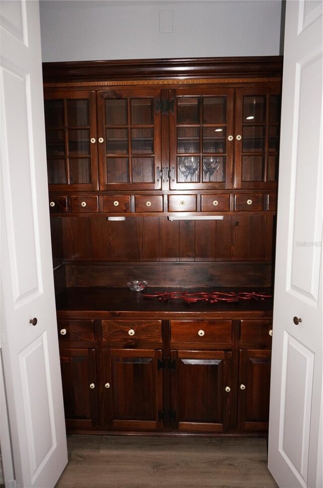 bar featuring dark brown cabinets and wood-type flooring