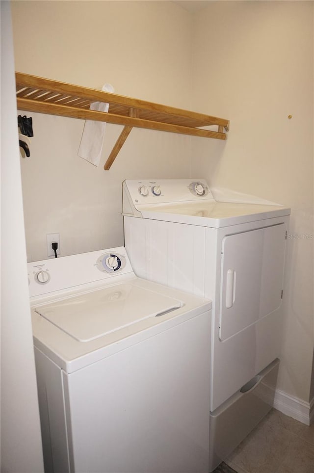 clothes washing area featuring washing machine and dryer and tile patterned flooring