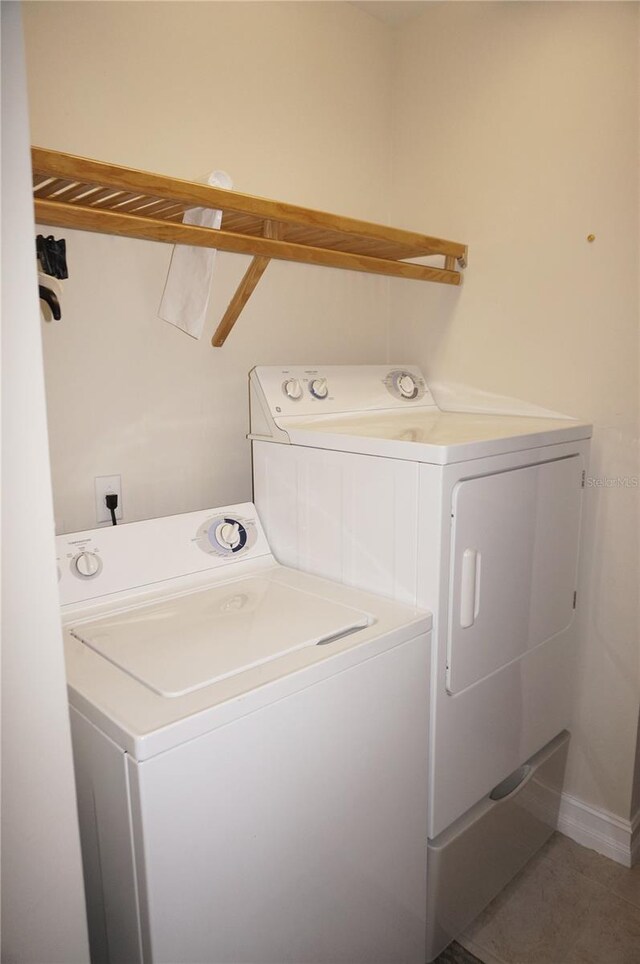 clothes washing area featuring washing machine and dryer and tile patterned flooring