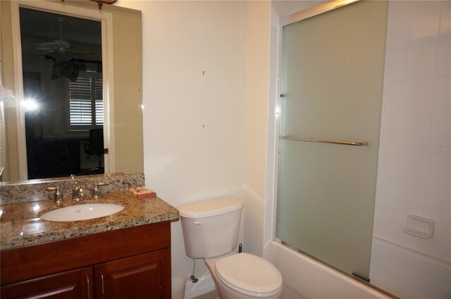 full bathroom featuring ceiling fan, toilet, shower / bath combination with glass door, and vanity