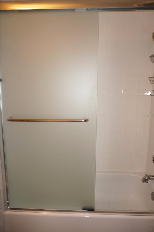 bathroom with shower / bath combination with glass door