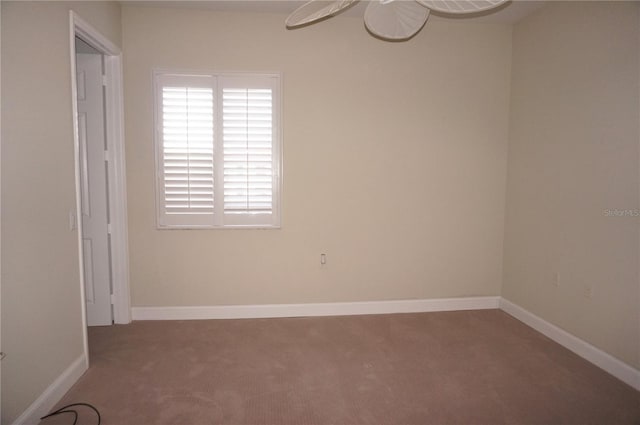 carpeted spare room featuring ceiling fan