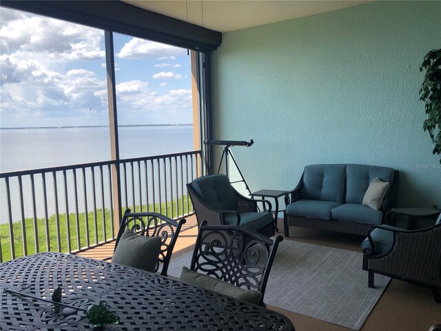 sunroom featuring a water view