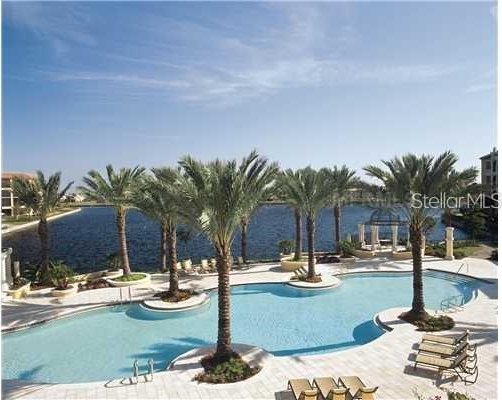 view of pool with a water view and a patio