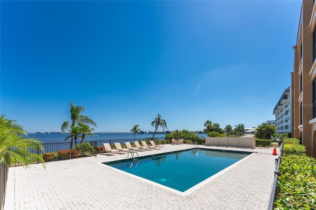 view of pool featuring a patio area and a water view