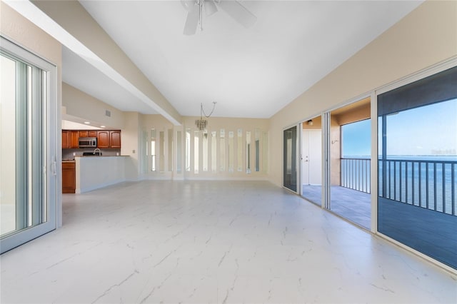 interior space featuring ceiling fan with notable chandelier