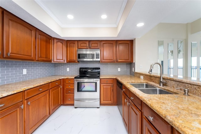 kitchen with a raised ceiling, sink, light stone countertops, appliances with stainless steel finishes, and tasteful backsplash