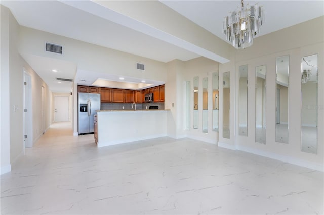 unfurnished living room featuring sink and an inviting chandelier