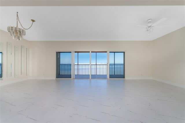 empty room featuring ceiling fan with notable chandelier