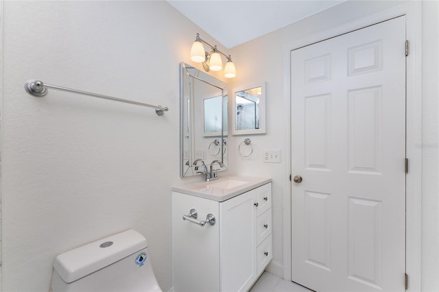 bathroom featuring tile patterned flooring, vanity, and toilet