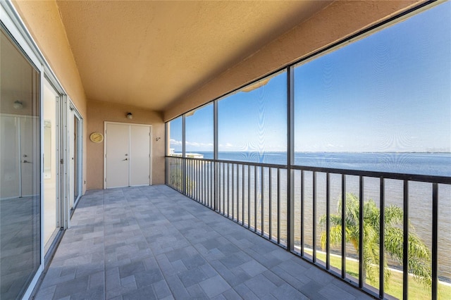 unfurnished sunroom featuring a water view