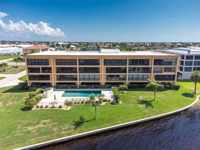 view of swimming pool featuring a water view and a yard