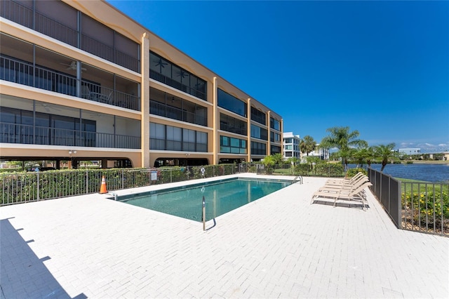 view of pool with a patio and a water view