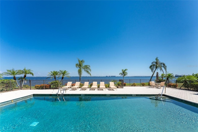 view of pool featuring a water view and a patio