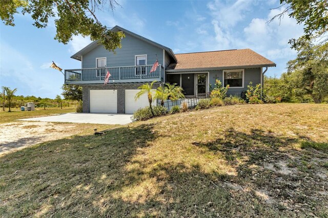 tri-level home with a garage, a front yard, and a balcony