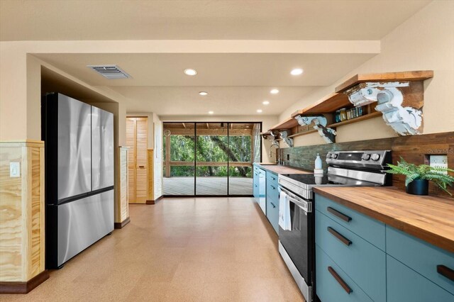 kitchen with visible vents, butcher block counters, appliances with stainless steel finishes, blue cabinetry, and light floors