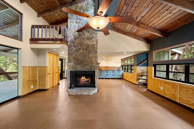 unfurnished living room featuring a wealth of natural light, wood ceiling, a fireplace, and beamed ceiling