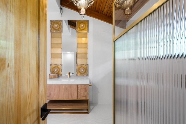 bathroom with beamed ceiling and vanity