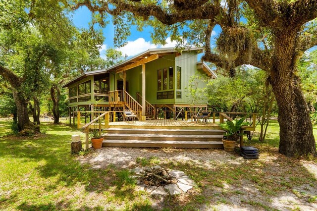 rear view of property featuring a lawn and a wooden deck