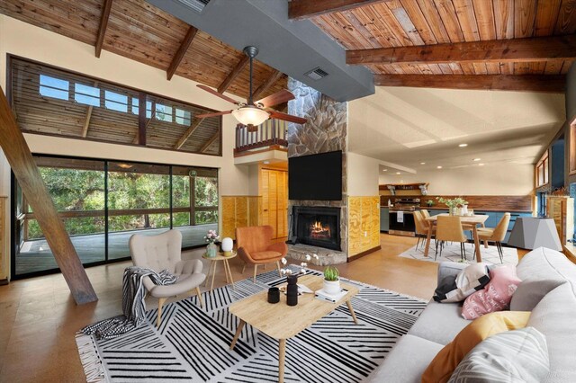 living area featuring visible vents, wood ceiling, beamed ceiling, a stone fireplace, and high vaulted ceiling