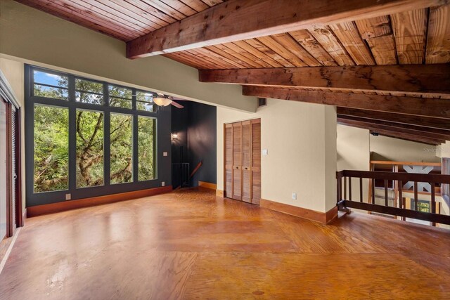 unfurnished room featuring a ceiling fan, wooden ceiling, beamed ceiling, and baseboards