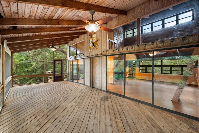 unfurnished sunroom featuring lofted ceiling with beams, wood ceiling, and a ceiling fan