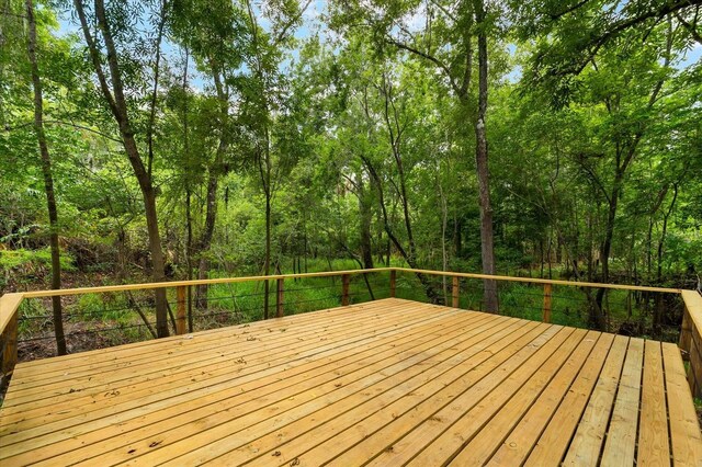 wooden deck with a wooded view