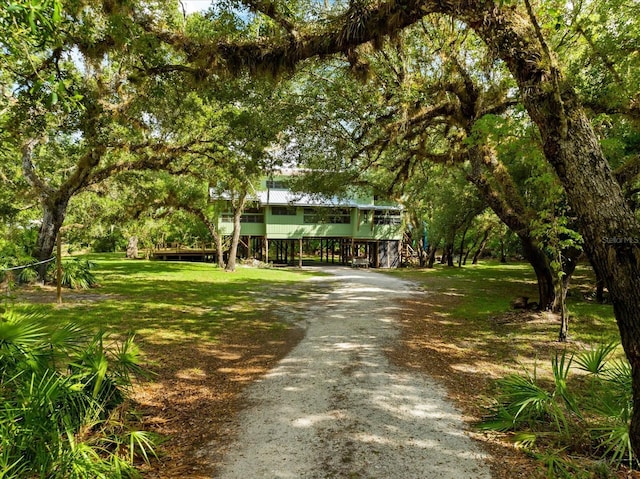 view of front of property featuring driveway, stairway, and a front lawn