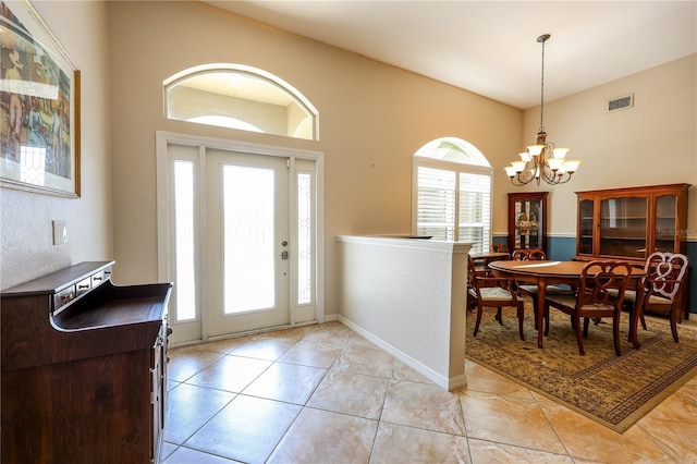 tiled entrance foyer featuring a notable chandelier and a wealth of natural light