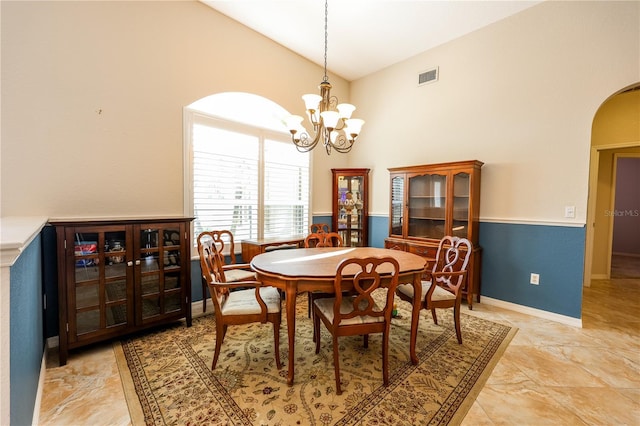 dining space with high vaulted ceiling and a notable chandelier