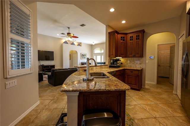 kitchen with ceiling fan, sink, backsplash, kitchen peninsula, and light tile patterned floors