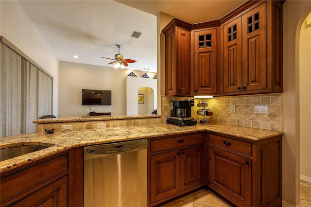 kitchen featuring dishwasher, decorative backsplash, ceiling fan, light stone countertops, and light tile patterned flooring