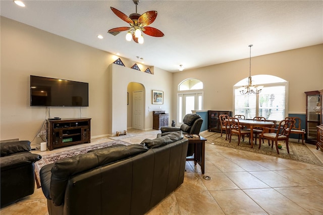 tiled living room featuring a textured ceiling and ceiling fan with notable chandelier