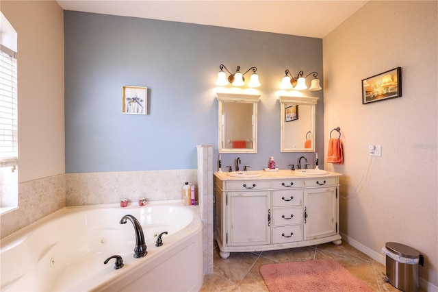 bathroom with a washtub, vanity, and tile patterned flooring