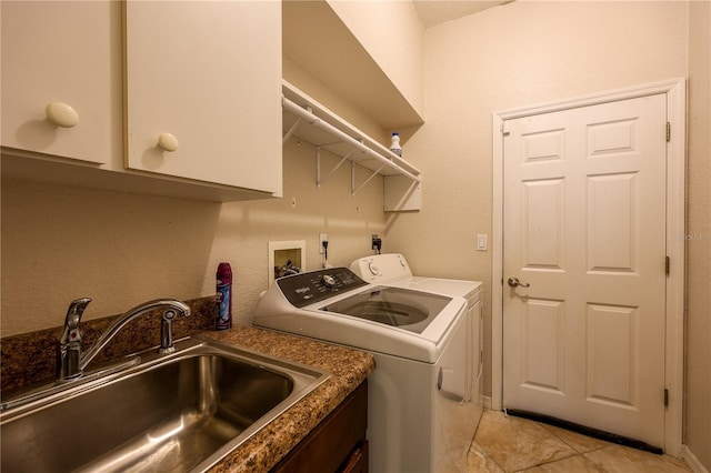 washroom featuring cabinets, light tile patterned floors, sink, and washing machine and clothes dryer