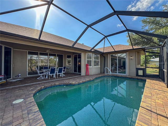 view of swimming pool with glass enclosure and a patio area