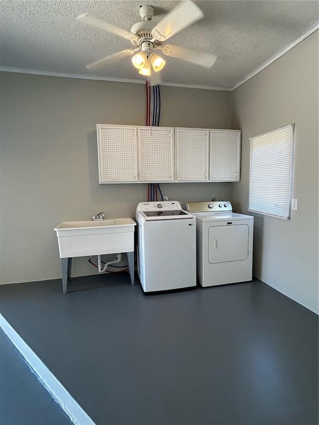 washroom featuring cabinets, sink, ceiling fan, washing machine and dryer, and a textured ceiling