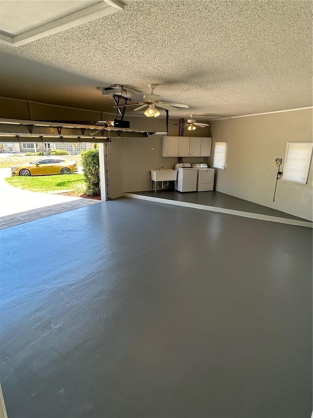 garage featuring washer and clothes dryer, a garage door opener, and sink