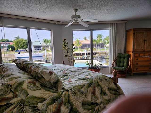 bedroom featuring access to exterior, multiple windows, ceiling fan, and light tile patterned flooring