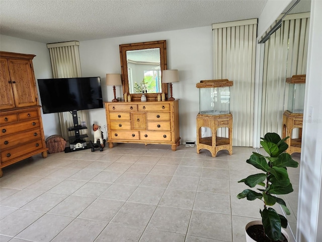 living area with light tile patterned floors and a textured ceiling