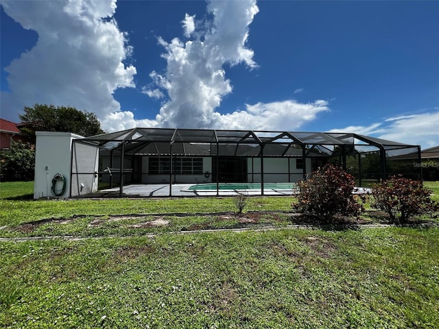 back of house featuring a patio, a lanai, and a lawn