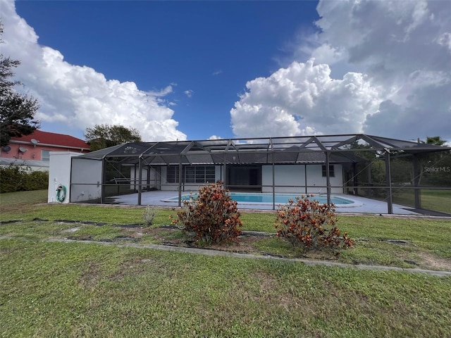 back of house with a patio, a yard, and glass enclosure