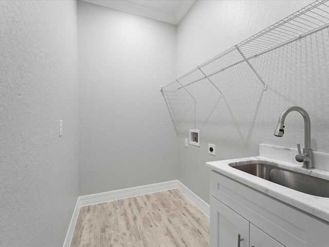 clothes washing area with electric dryer hookup, cabinets, sink, washer hookup, and light hardwood / wood-style flooring