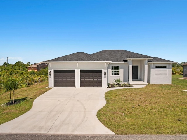 prairie-style house featuring a garage and a front yard