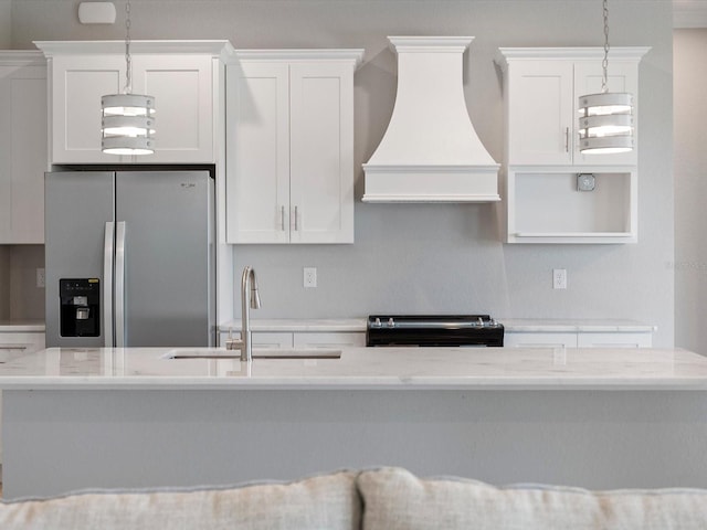 kitchen with stainless steel fridge, custom range hood, pendant lighting, sink, and white cabinets