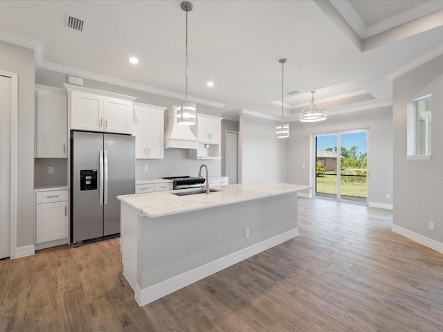 kitchen featuring white cabinetry, sink, a kitchen island with sink, light hardwood / wood-style flooring, and stainless steel fridge with ice dispenser