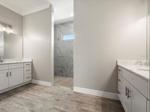 bathroom featuring ornamental molding, hardwood / wood-style floors, vanity, and tiled shower